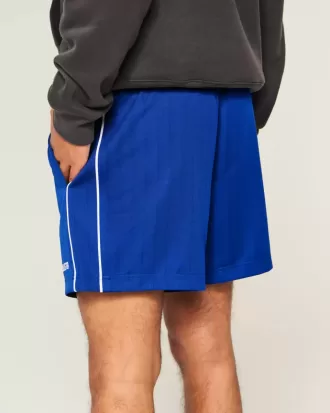 Fotbollsshorts med stickad logotyp på mitten av låret